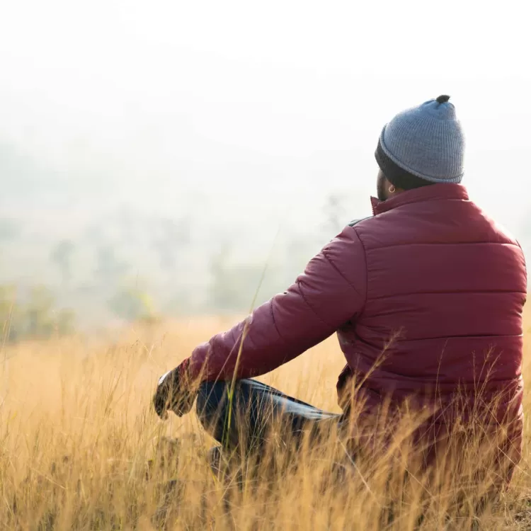 Man meditating in field