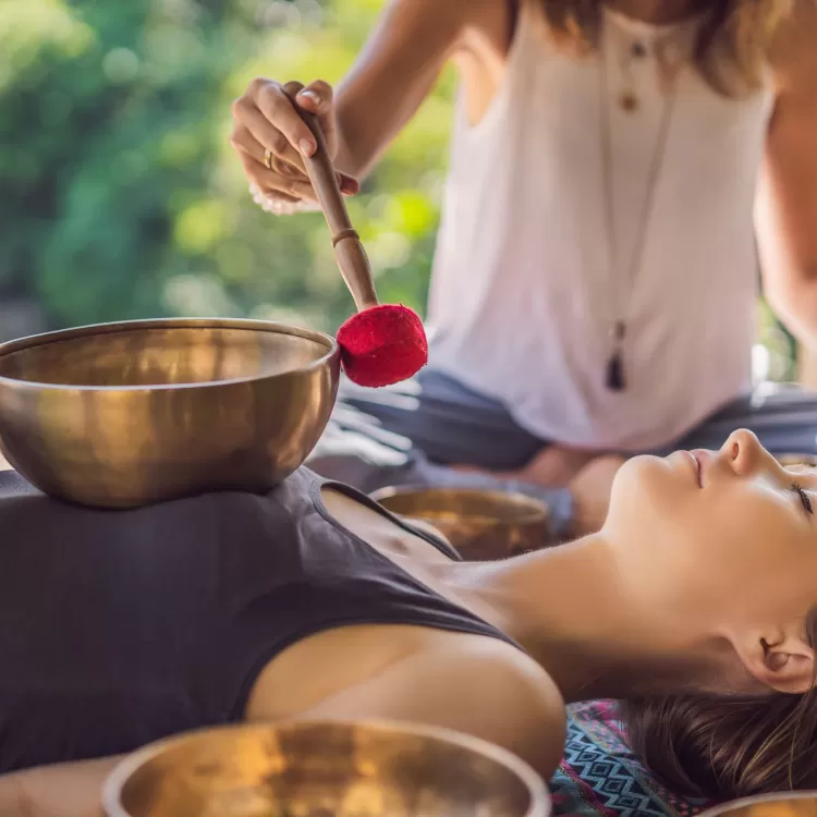 A professional masseur performs chakra stimulation with Tibetan bells