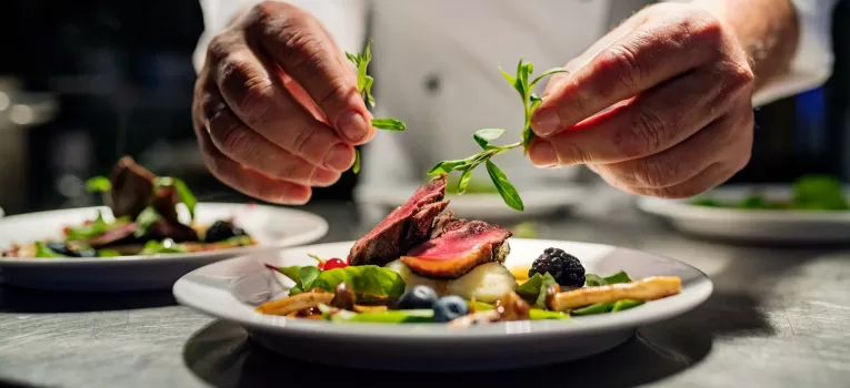 Chef preparing fine dining meal in restaurant kitchen